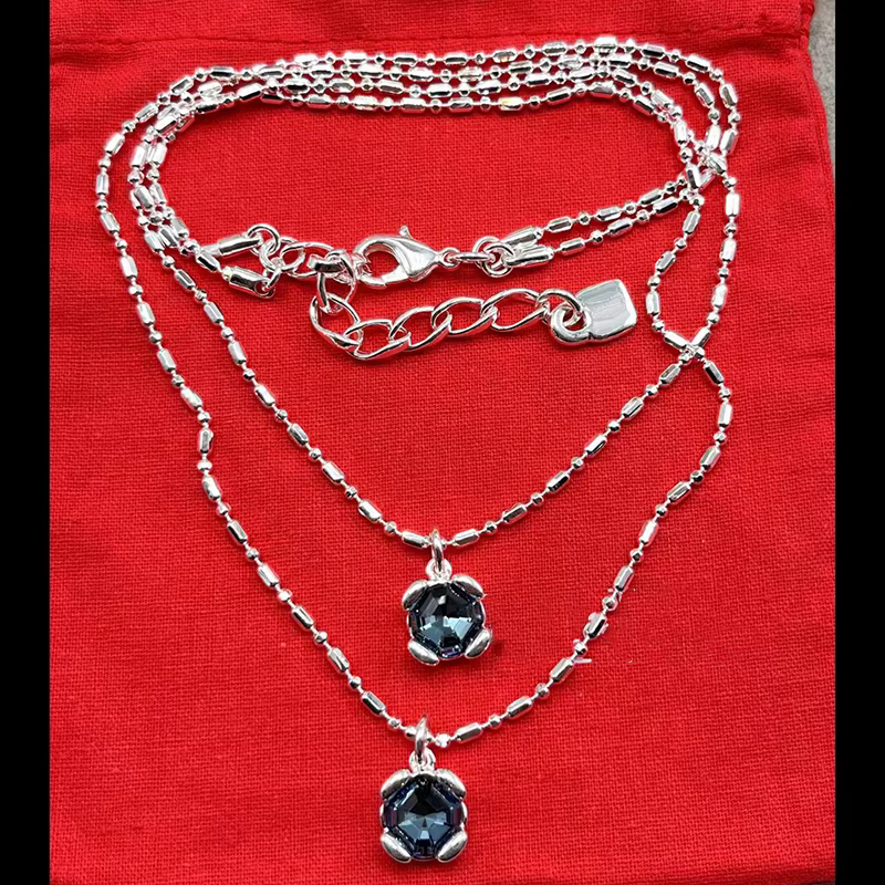 Bijoux faits à la main Se. Colliers et bracelets en tons or/argent avec pendentifs en cristal et dessins de chaînes.